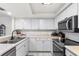 Clean kitchen features white cabinets, stone countertops, stainless steel appliances, and undermount sink at 15 Casarena Ct, Winter Haven, FL 33881