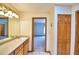 Bathroom with wood cabinets and tile floors leads to a bedroom and closet at 151 W Hamlin Trl, Frostproof, FL 33843