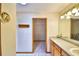 Bathroom featuring white tile floors, a wood vanity, and a glimpse of a walk-in closet at 151 W Hamlin Trl, Frostproof, FL 33843