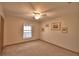 Carpeted bedroom with a ceiling fan, a window with curtains, and wall decorations at 151 W Hamlin Trl, Frostproof, FL 33843
