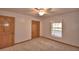 Bedroom showcasing carpet, a window with curtains, a ceiling fan, and a wood closet door at 151 W Hamlin Trl, Frostproof, FL 33843