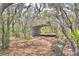 Backyard carport with bench seating surrounded by mature trees and foliage at 151 W Hamlin Trl, Frostproof, FL 33843