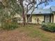 Side of house showcasing mature landscaping, yellow siding and a green roof at 151 W Hamlin Trl, Frostproof, FL 33843