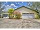 Charming home featuring an attached garage, colorful shrubbery, and a well-maintained driveway at 151 W Hamlin Trl, Frostproof, FL 33843