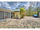 Back patio with a small garden, green roof, and blue car parked in the driveway at 151 W Hamlin Trl, Frostproof, FL 33843
