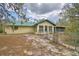 Back of house view of property with a metal roof, lawn and partial fence at 151 W Hamlin Trl, Frostproof, FL 33843
