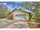 Two-car garage with white door and path to screened porch and house at 151 W Hamlin Trl, Frostproof, FL 33843