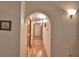 Well-lit hallway with hardwood floors, neutral walls, arched doorway, and access to other rooms at 151 W Hamlin Trl, Frostproof, FL 33843