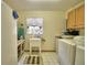 Functional laundry room offering a utility sink, tiled floors, cabinets, and appliances at 151 W Hamlin Trl, Frostproof, FL 33843