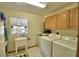 Bright laundry room featuring a utility sink, tile floors, cabinets, washer, and dryer at 151 W Hamlin Trl, Frostproof, FL 33843