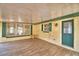 Enclosed patio with wood-look tile flooring, natural light, and a teal door at 151 W Hamlin Trl, Frostproof, FL 33843