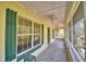 Charming screened-in porch with tiled floors, ceiling fans, and green window shutters at 151 W Hamlin Trl, Frostproof, FL 33843