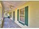 Charming screened-in porch with tiled floors, ceiling fans, and green window shutters at 151 W Hamlin Trl, Frostproof, FL 33843
