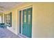 Covered porch with green door, window, and textured stucco wall at 151 W Hamlin Trl, Frostproof, FL 33843