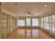 Inviting sun room with hardwood floors, natural light, and multiple windows with sheer curtains at 151 W Hamlin Trl, Frostproof, FL 33843