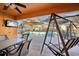 A covered patio features tile flooring, ceiling fan, TV, table and chairs, and swing with a view of the screened-in pool area at 1621 Normandy Heights Blvd, Winter Haven, FL 33880