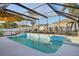 The swimming pool features a screened enclosure and a yellow umbrella that provides shade for the pool deck at 1621 Normandy Heights Blvd, Winter Haven, FL 33880