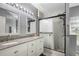 Modern bathroom featuring dual sinks, granite counters, and a beautifully tiled glass-enclosed shower at 1817 Manitoba Ct, Poinciana, FL 34759