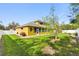 Landscaped backyard, featuring screened lanai, tree, and partial fence at 1904 Eloise Cove Dr, Winter Haven, FL 33884