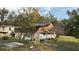 Damaged exterior of unfinished home with partial siding and roof repairs and debris at 1928 Old Apopka Rd, Apopka, FL 32703