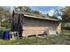 Damaged exterior of unfinished home with partial siding and roof repairs, debris, and refuse at 1928 Old Apopka Rd, Apopka, FL 32703