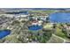Beautiful aerial shot of homes near a lake, with a pool and lovely green landscaping at 208 Country Ne Ln # 208, Winter Haven, FL 33881