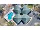 Aerial view of a home and pool with a unique roof design in a lushly landscaped area at 208 Country Ne Ln # 208, Winter Haven, FL 33881