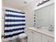 Bright bathroom featuring a shower with blue and white striped curtain at 208 Country Ne Ln # 208, Winter Haven, FL 33881