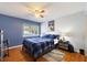 Comfortable bedroom with hardwood floors, ceiling fan and blue accents at 208 Country Ne Ln # 208, Winter Haven, FL 33881