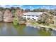 Back view of a waterfront condo with a lakefront view surrounded by trees at 208 Country Ne Ln # 208, Winter Haven, FL 33881