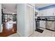 Galley kitchen featuring stainless steel appliances, white cabinets, and tile flooring at 208 Country Ne Ln # 208, Winter Haven, FL 33881