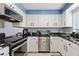 Galley kitchen featuring black granite countertops, white cabinets, and stainless steel appliances at 208 Country Ne Ln # 208, Winter Haven, FL 33881