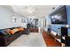 Open-concept living room featuring hardwood floors, a large leather sofa, and views into the kitchen at 208 Country Ne Ln # 208, Winter Haven, FL 33881