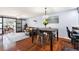 Open-concept living room featuring hardwood floors, sliding glass doors, dining area, and leather sofa at 208 Country Ne Ln # 208, Winter Haven, FL 33881