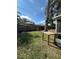 Green backyard features table, mature shade tree, and fenced perimeter for privacy at 229 Durrell Rd, Winter Haven, FL 33884