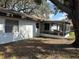 Back exterior view of home with screened in patio and mature shade tree at 229 Durrell Rd, Winter Haven, FL 33884