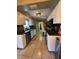 Galley style kitchen features stainless steel appliances, white cabinets, dark countertops, and tile backsplash at 229 Durrell Rd, Winter Haven, FL 33884