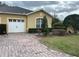 Charming single-Gathering home features an attached garage, brick driveway, and manicured landscaping at 2673 Rutledge Ct, Winter Haven, FL 33884