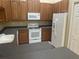 Well-equipped kitchen featuring a white refrigerator, oven, microwave, and wood cabinets at 2673 Rutledge Ct, Winter Haven, FL 33884