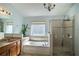Luxurious bathroom with soaking tub, glass-enclosed shower, and granite countertop vanity at 2706 Rochelle Dr, Winter Haven, FL 33881