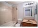 Cozy bathroom featuring a vanity, bathtub-shower with peach tile, and mirrored lighting at 2706 Rochelle Dr, Winter Haven, FL 33881