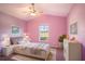 Cozy bedroom with pink walls, a ceiling fan, and natural light from a window at 2706 Rochelle Dr, Winter Haven, FL 33881