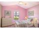Bedroom features soft pink walls, artwork, and a comfortable bed with throw blanket at 2706 Rochelle Dr, Winter Haven, FL 33881