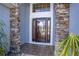Inviting front door with decorative glass, stone pillars, and tile entry at 2706 Rochelle Dr, Winter Haven, FL 33881