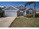 Charming single-story home with a two-car garage, stone accents, and landscaped front yard at 2706 Rochelle Dr, Winter Haven, FL 33881