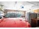 View of a residential garage featuring a red car, storage shelves and a working garage door opening mechanism at 2706 Rochelle Dr, Winter Haven, FL 33881