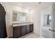 Bathroom with double vanity, granite countertop, large mirror, and tile floors at 2759 Grandbury Grove Rd, Lakeland, FL 33811