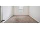 Bright bedroom features a neutral carpet, white walls, and a window letting in natural light at 2759 Grandbury Grove Rd, Lakeland, FL 33811
