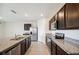 Open kitchen with stainless appliances, granite countertops, and dark cabinetry at 2759 Grandbury Grove Rd, Lakeland, FL 33811