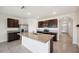 Open kitchen features stainless appliances, dark wood cabinets and large center island with granite countertops at 2759 Grandbury Grove Rd, Lakeland, FL 33811